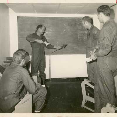 4 Unknown men in uniform talking in an office