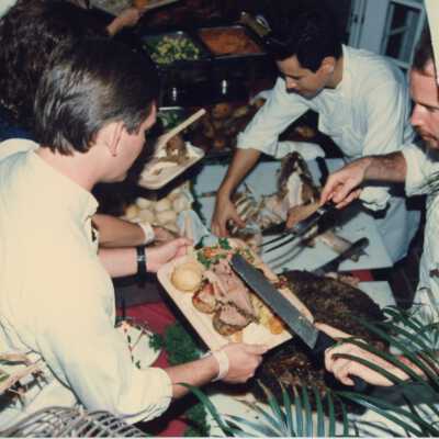 Unknown people serving themselves food from a buffet table.