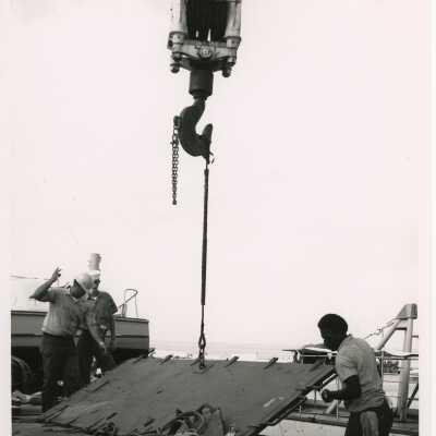 A crane lifting something a U.S. Navy dock