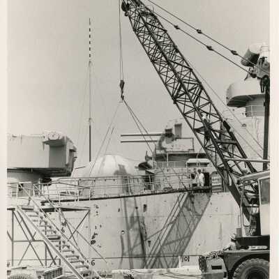 A crane lifting things into a ship