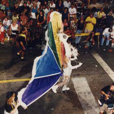 An unknown person dressed up and walking down the street for the parade.