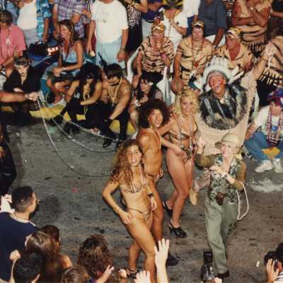 Unknown people dressed up walking in the street for the parade.