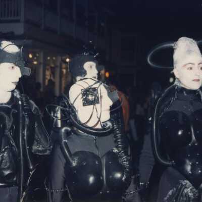 Unknown people dressed up walking in the street for the parade.