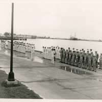 A group of men in uniform standing by the pier