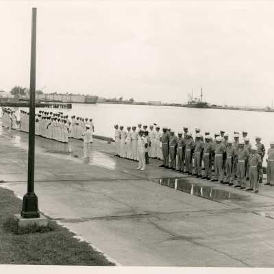 A group of men in uniform standing by the pier
