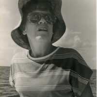 An unknown woman with an ocean view behind her