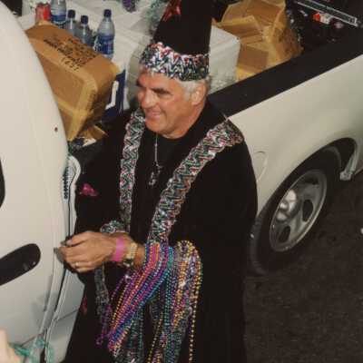 Unknown man dressed up passing out beads.