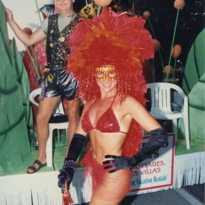 Unknown woman dressed up standing next to a float.