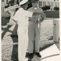 2 Unknown men in uniform standing outside on base talking to each other