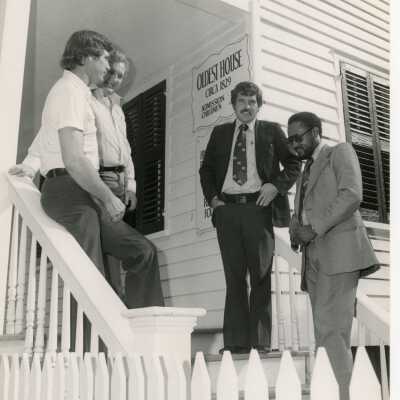 4 Unknown men standing outside of the oldest house