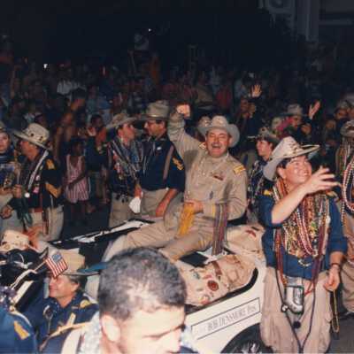 Unknown people walking near a float in the parade.