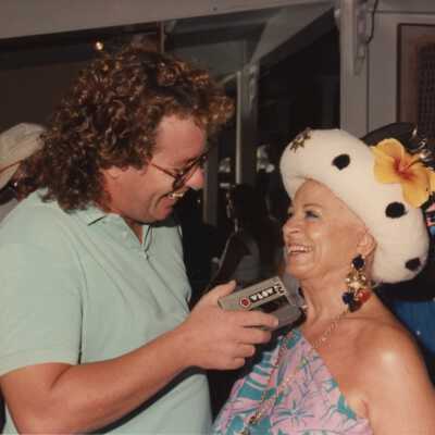 Unknown man holding a voice recorder talking to an unknown woman.