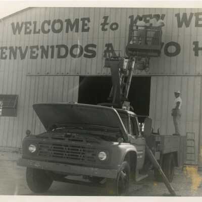 A truck putting up a sign on a building