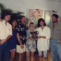 A group of unknown people accepting a trophy.