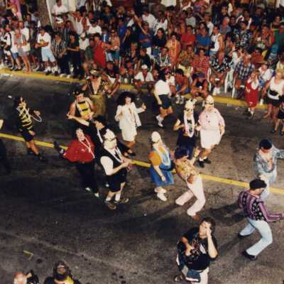 Unknown people dancing in the street in the parade.