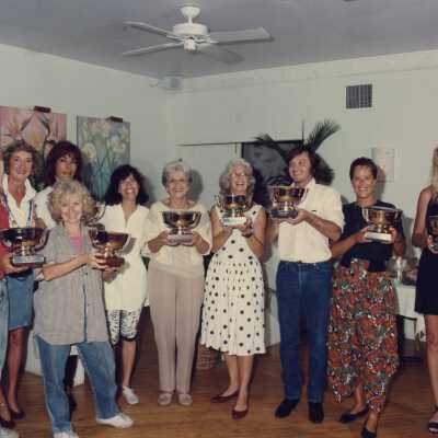 A group of unknown people accepting a trophy.