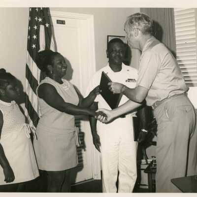 An unknown man presenting a family a plaque