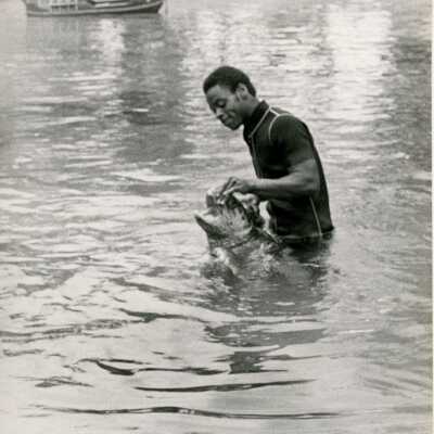 An unknown man in the water with a turtle