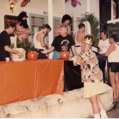 Unknown people standing around a table talking outside of the Tropical Inn at 812 Duval street.