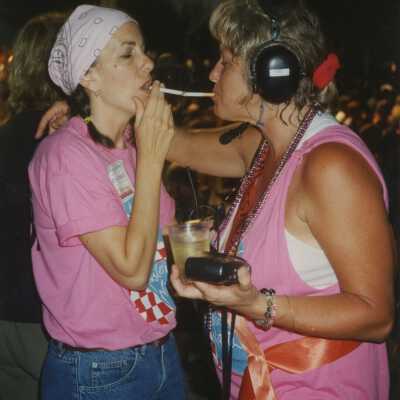 Two unknown woman lighting cigarettes.