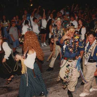 Unknown people dressed up walking in the street for the parade.