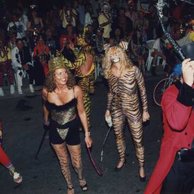 Unknown people dressed up walking in the street for the parade.
