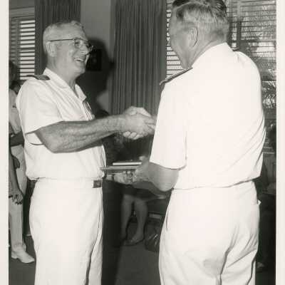 2 Men in uniform shaking hands and receiving a plaque