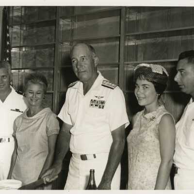 A group of unknown people at a party, a few in uniform