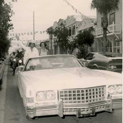 An unknown couple sitting on a car