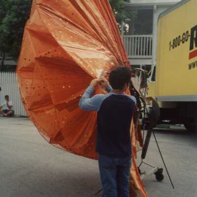 An unknown man preparing an object that will be in the parade.