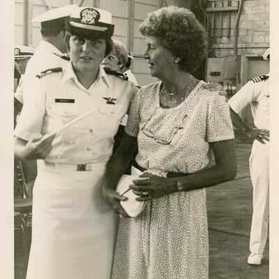 A lady in uniform standing with a woman