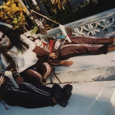Three unknown people dressed up at the cemetery.
