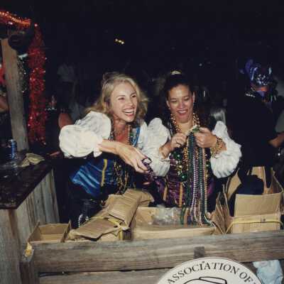 Two unknown woman dressed up opening boxes of beads.