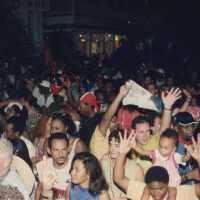 A group of unknown people walking down the street.
