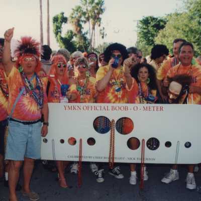 Unknown people dressed up holding a board that reads YMKN official Boob o meter.