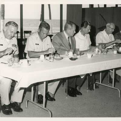 A group of men eating at a table, a few in uniform