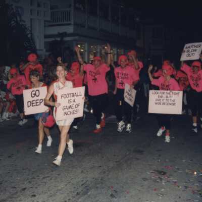 Unknown people dressed up walking in the street for the parade.