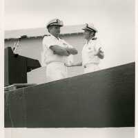 2 Men in uniform talking next to a podium