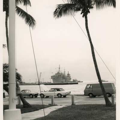 A military ship and a few cars parked