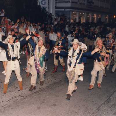 Unknown people dressed up walking down the street in a parade.