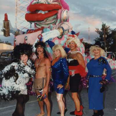 Unknown people dressed up standing near a float.
