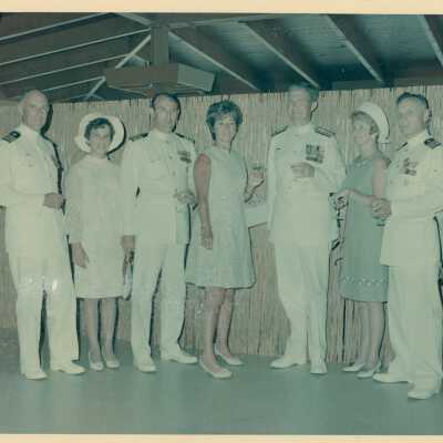 Unknown woman and men in uniform standing at a party