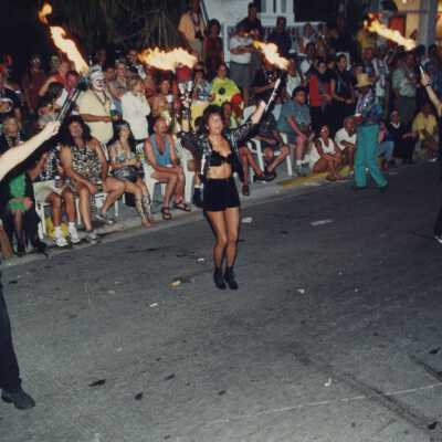 Unknown people dressed up juggling with fire in the parade.