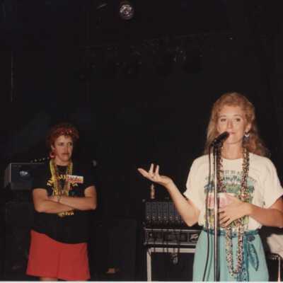Unknown woman on a stage, one is talking into a microphone.