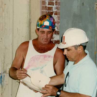 Two unknown men going over plans.