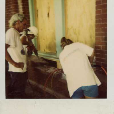 Three unknown people working on the exterior.