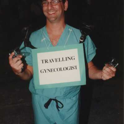 An unknown man dressed up, his costume reads traveling gyn.