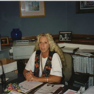 An unknown woman sitting at a desk.