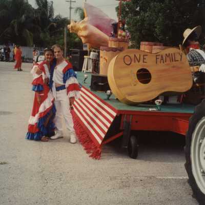 Two unknown people dressed up standing near a float.