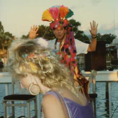 Two unknown people dressed up standing near the water.